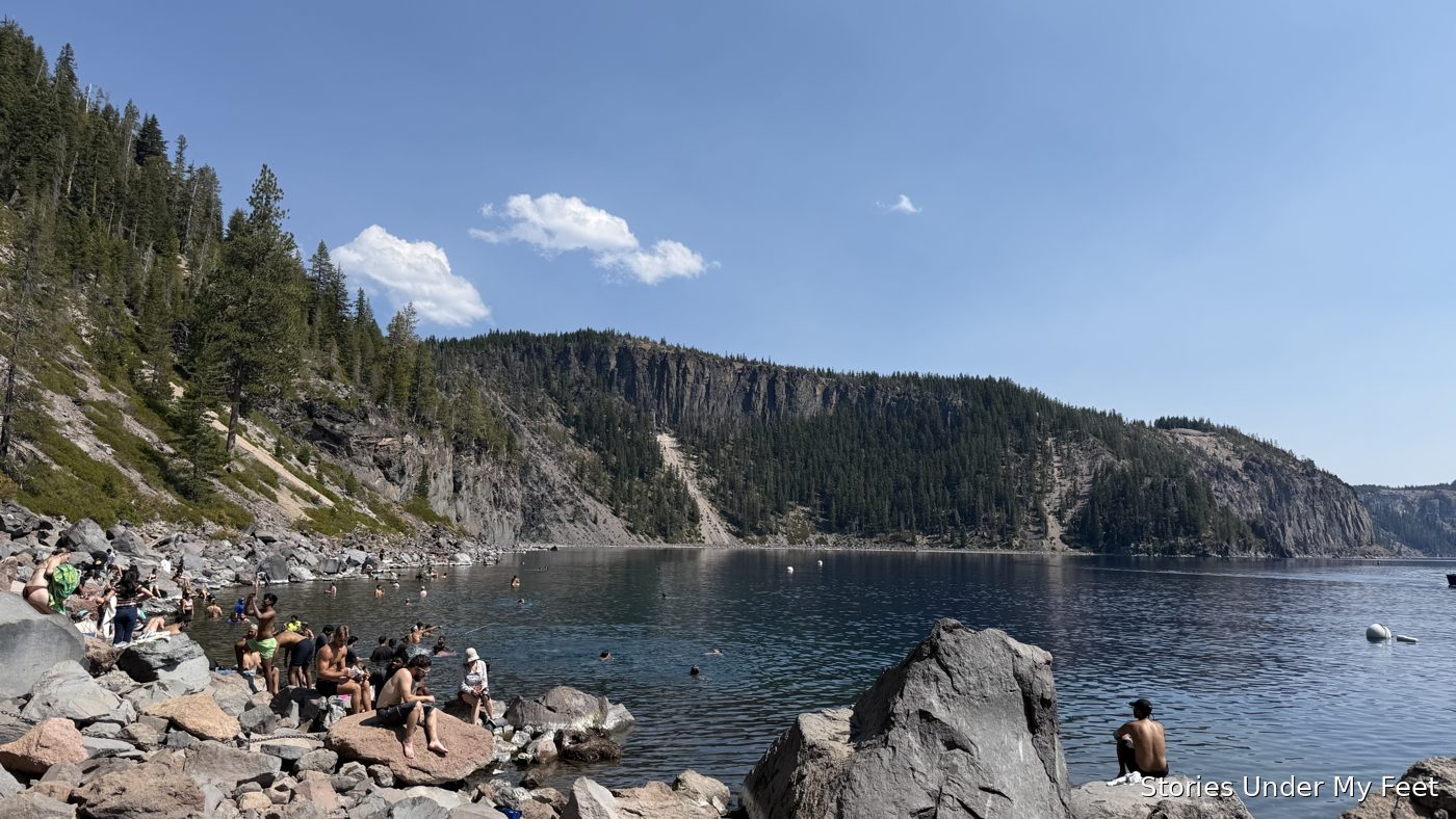 Swimmers and sunbathers on the rocks at the lake's edge at Cleetwood Cove